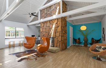 A room with a stone fireplace and wooden floors.